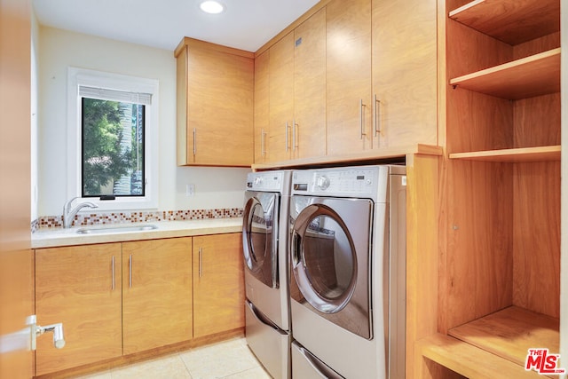 laundry area featuring sink, washing machine and dryer, cabinets, and light tile patterned flooring