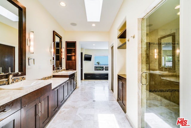 bathroom with vanity, a skylight, and a shower with shower door