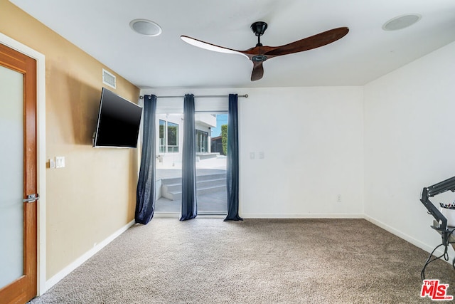 spare room featuring carpet and ceiling fan