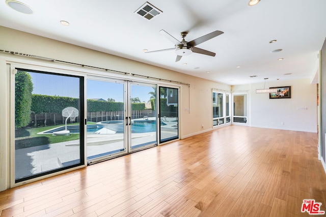 unfurnished living room with ceiling fan, a healthy amount of sunlight, and light hardwood / wood-style floors