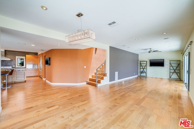 living room featuring light hardwood / wood-style flooring and ceiling fan