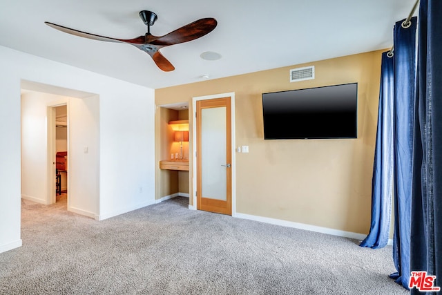 unfurnished bedroom featuring ceiling fan and light carpet