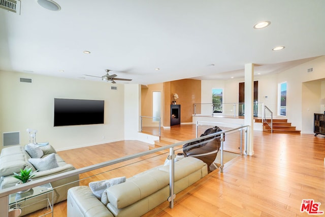 living room featuring ceiling fan and light hardwood / wood-style flooring