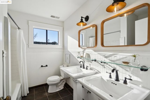 bathroom featuring shower / tub combo, double sink, tile patterned floors, and toilet