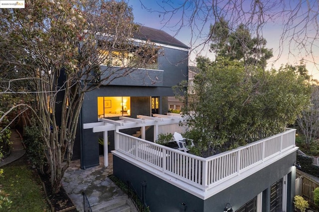 back house at dusk with a balcony