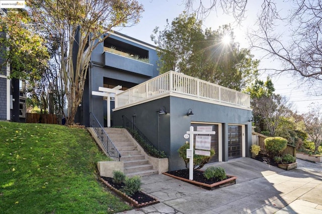 contemporary home with a garage, a balcony, and a front lawn