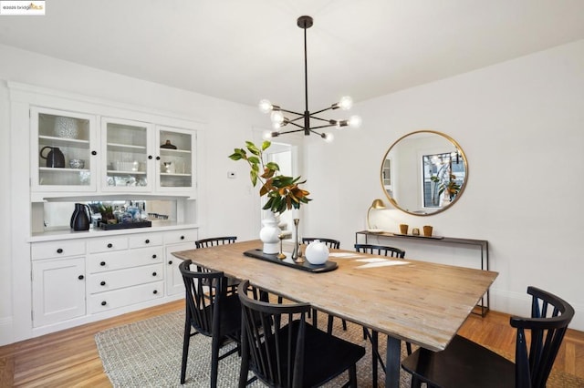 dining space with an inviting chandelier and light hardwood / wood-style flooring