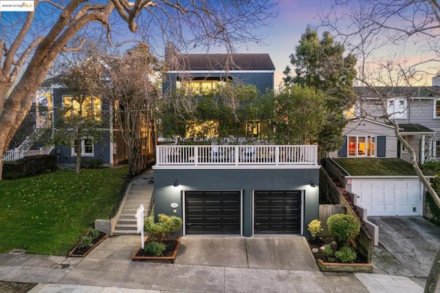 view of front of house with a garage, a lawn, and a balcony