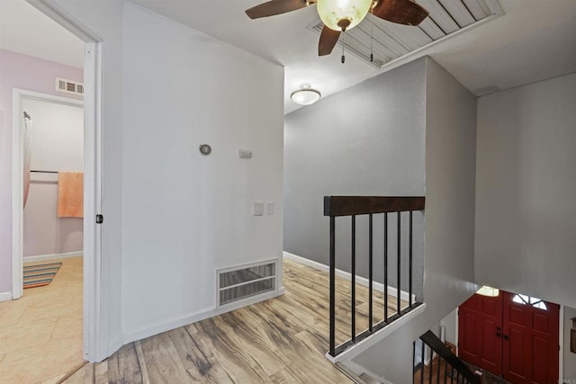 stairs with hardwood / wood-style flooring and ceiling fan