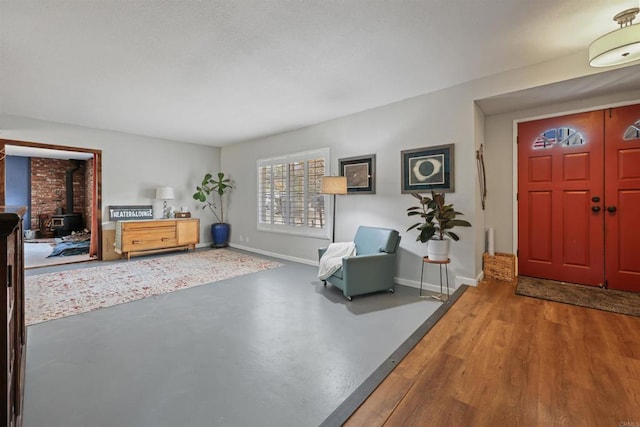 foyer entrance with a wood stove and concrete floors