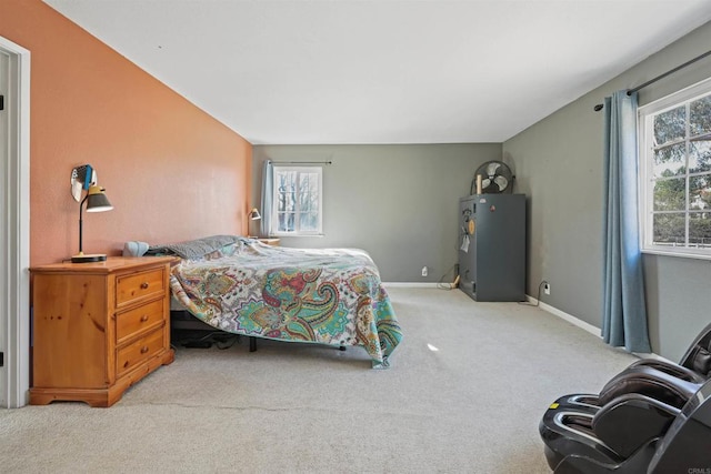 bedroom with multiple windows, light colored carpet, and baseboards