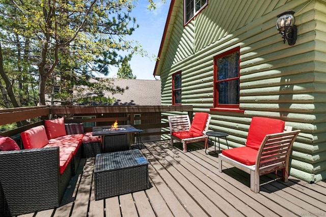 wooden terrace with an outdoor living space with a fire pit