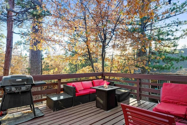 wooden deck featuring a grill and an outdoor living space with a fire pit