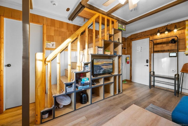 stairs featuring crown molding, hardwood / wood-style floors, and wood walls