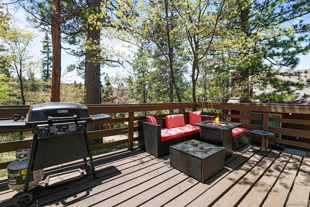 wooden terrace featuring grilling area and an outdoor living space with a fire pit