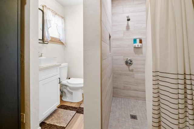 bathroom with a shower with curtain, toilet, sink, and hardwood / wood-style flooring