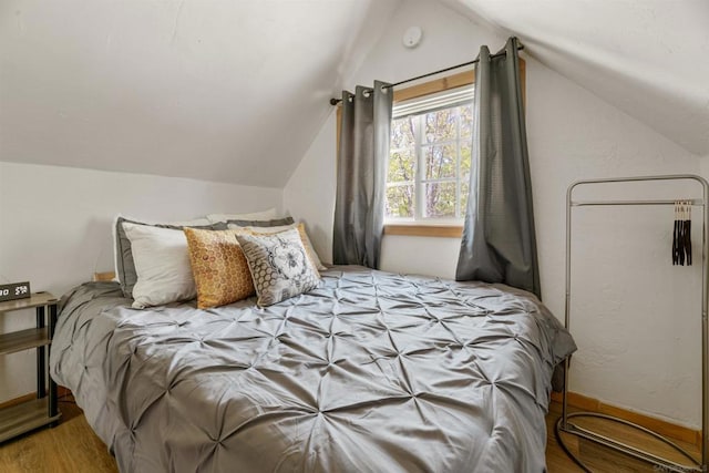 bedroom featuring lofted ceiling and light wood-type flooring