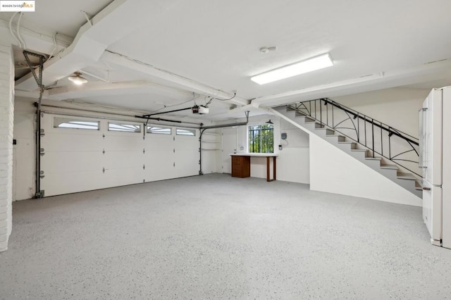 garage with white refrigerator and a garage door opener