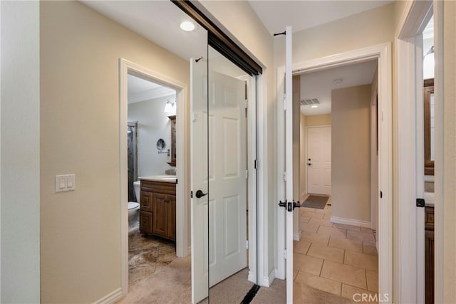 corridor featuring light carpet, baseboards, and visible vents