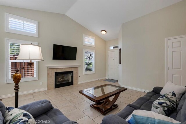 living room featuring a fireplace, high vaulted ceiling, and light tile patterned floors