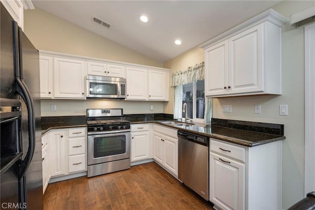 kitchen featuring vaulted ceiling, appliances with stainless steel finishes, dark hardwood / wood-style floors, sink, and white cabinets