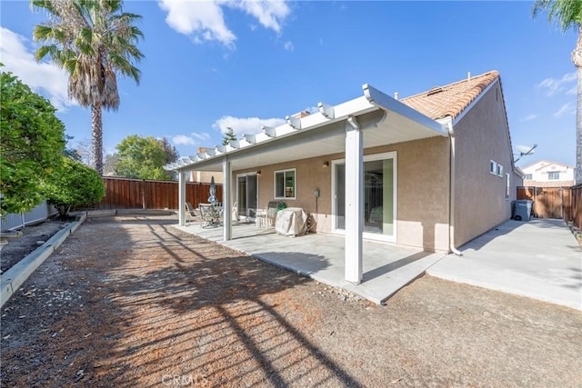 back of property with a fenced backyard, a patio, and stucco siding