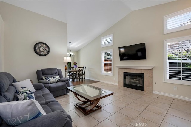 living room featuring light tile patterned floors, a tile fireplace, a chandelier, and high vaulted ceiling