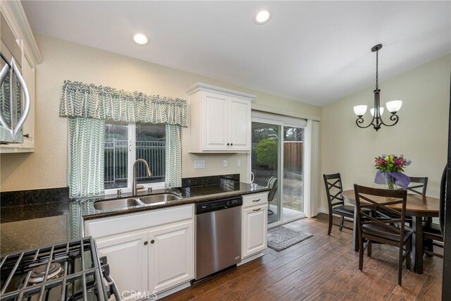 kitchen featuring appliances with stainless steel finishes, pendant lighting, white cabinetry, sink, and dark wood-type flooring