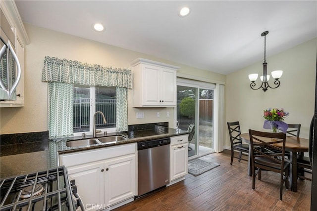 kitchen featuring dark wood-style flooring, pendant lighting, stainless steel appliances, white cabinets, and a sink