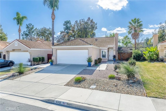 ranch-style home with a tile roof, stucco siding, an attached garage, fence, and driveway