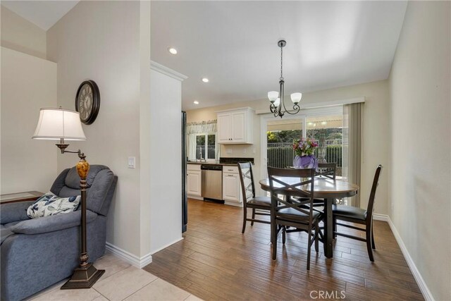 dining area with light hardwood / wood-style floors and a chandelier