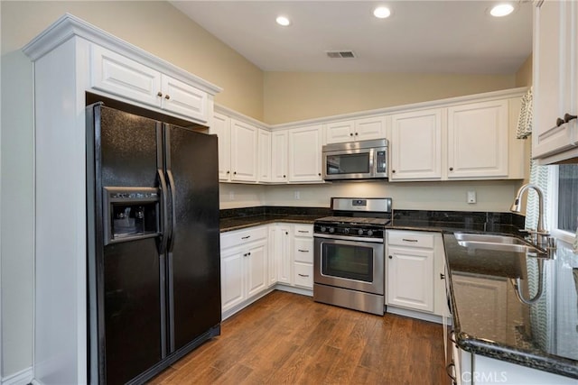 kitchen featuring lofted ceiling, appliances with stainless steel finishes, sink, and white cabinets