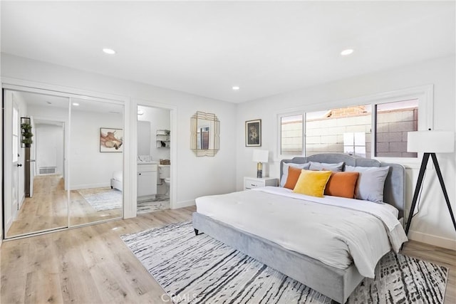 bedroom with ensuite bath and light wood-type flooring