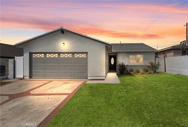 view of front of property featuring a garage and a lawn