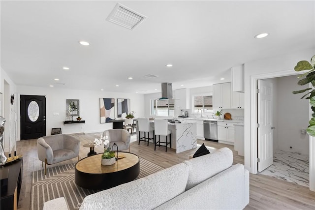 living room with sink and light hardwood / wood-style flooring