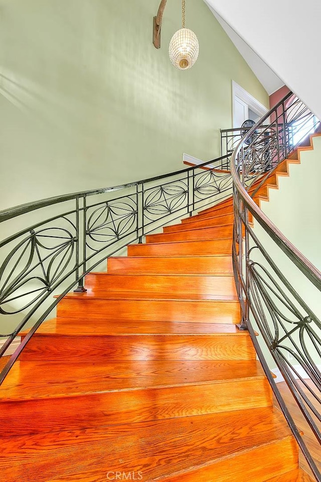 stairs with lofted ceiling and hardwood / wood-style floors