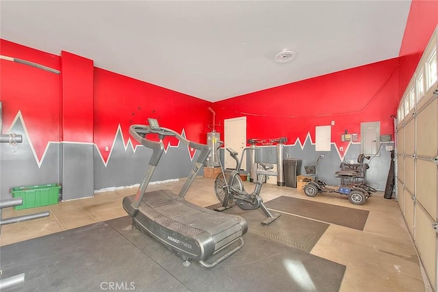 workout room featuring water heater and electric panel