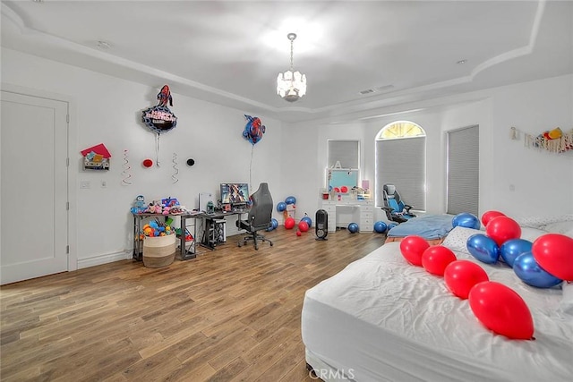 bedroom featuring hardwood / wood-style flooring and a chandelier