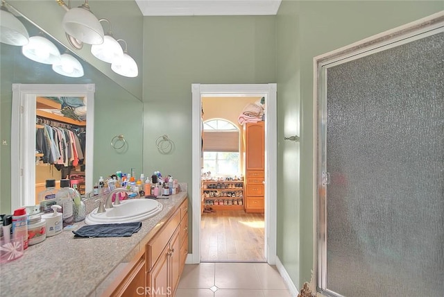 bathroom with tile patterned floors, a shower with door, and vanity