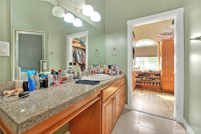 bathroom featuring tile patterned flooring, vanity, and an inviting chandelier