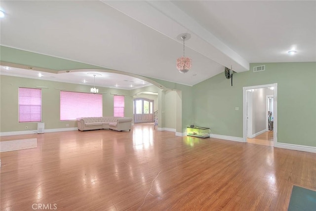 unfurnished living room with light hardwood / wood-style flooring and lofted ceiling with beams