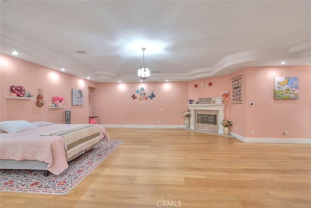 bedroom with a tray ceiling and light hardwood / wood-style floors