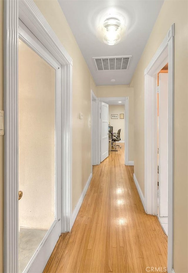 hallway with light hardwood / wood-style flooring