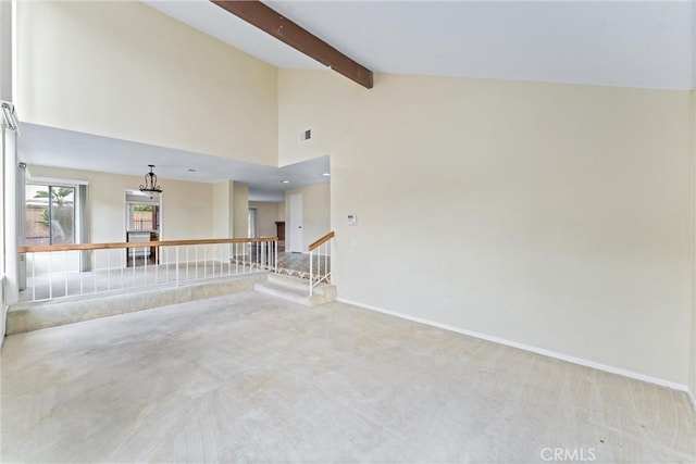 unfurnished room featuring beam ceiling, high vaulted ceiling, and light carpet