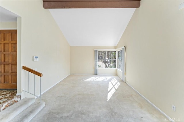 unfurnished room featuring vaulted ceiling with beams and light colored carpet