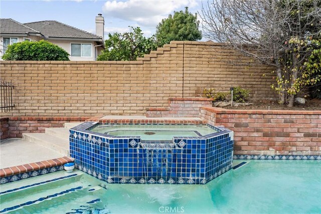 view of pool featuring an in ground hot tub