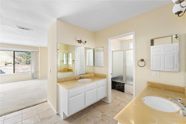 bathroom featuring tile patterned flooring, bath / shower combo with glass door, and vanity