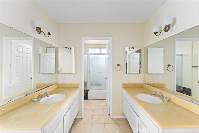 bathroom with tile patterned floors, vanity, and shower / bath combination with glass door