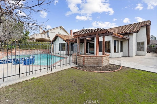 rear view of house featuring a swimming pool with hot tub, a pergola, a lawn, and a patio