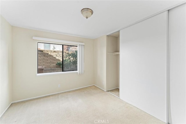 unfurnished bedroom with light carpet and a closet